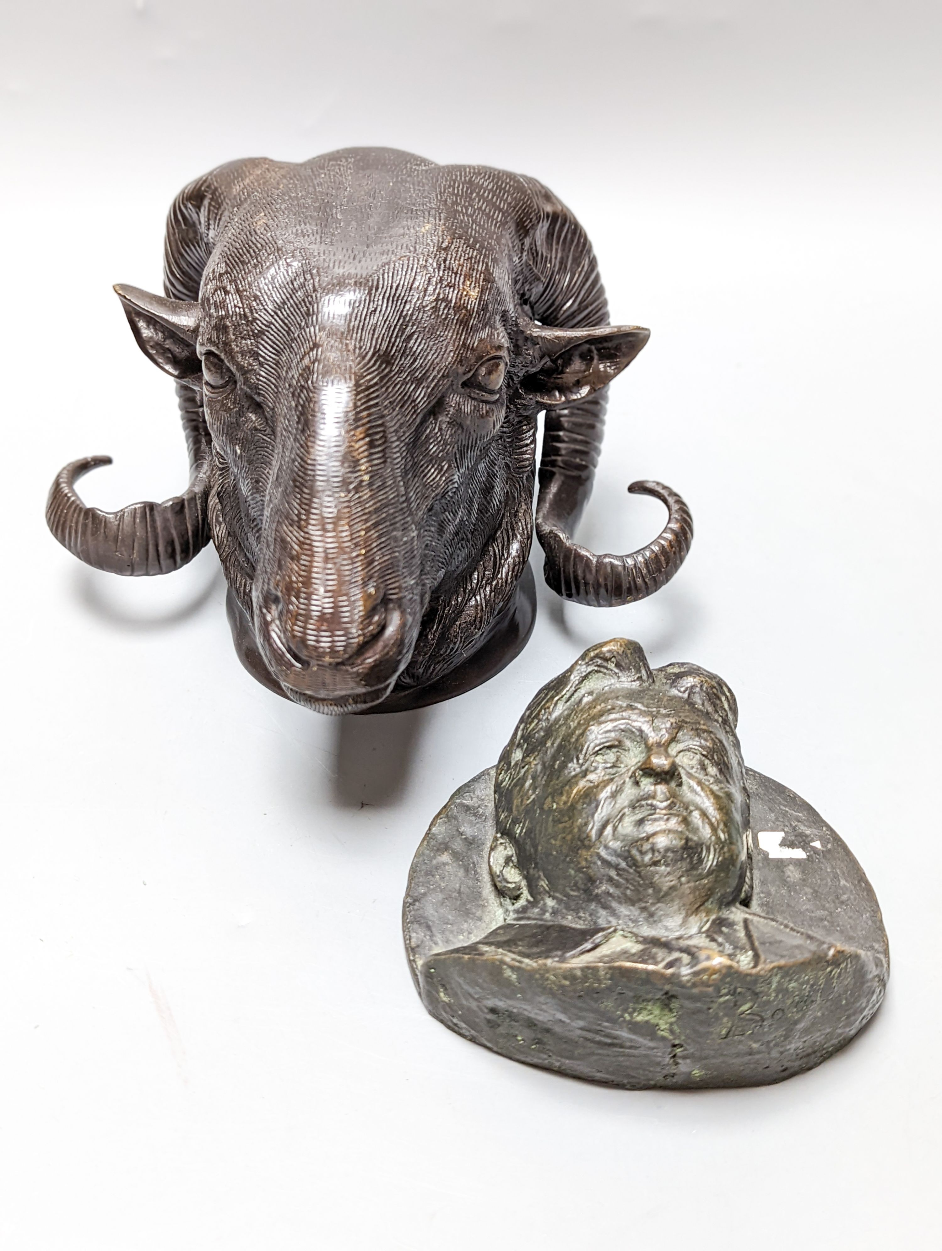 A bronze ram's head and a bronze relief